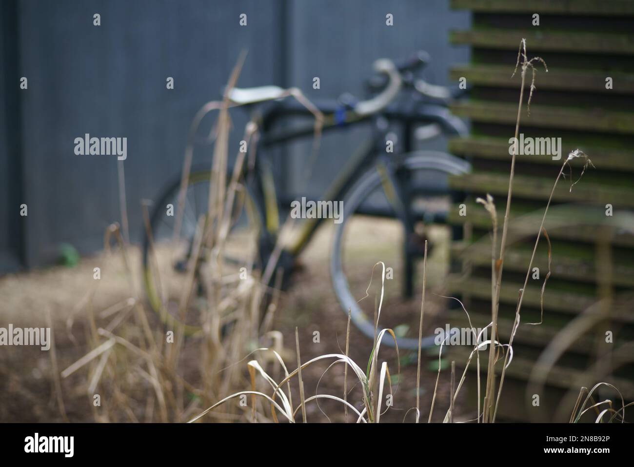 Flou artistique. Un vélo est stationné derrière un hangar dans un quartier résidentiel. Banque D'Images