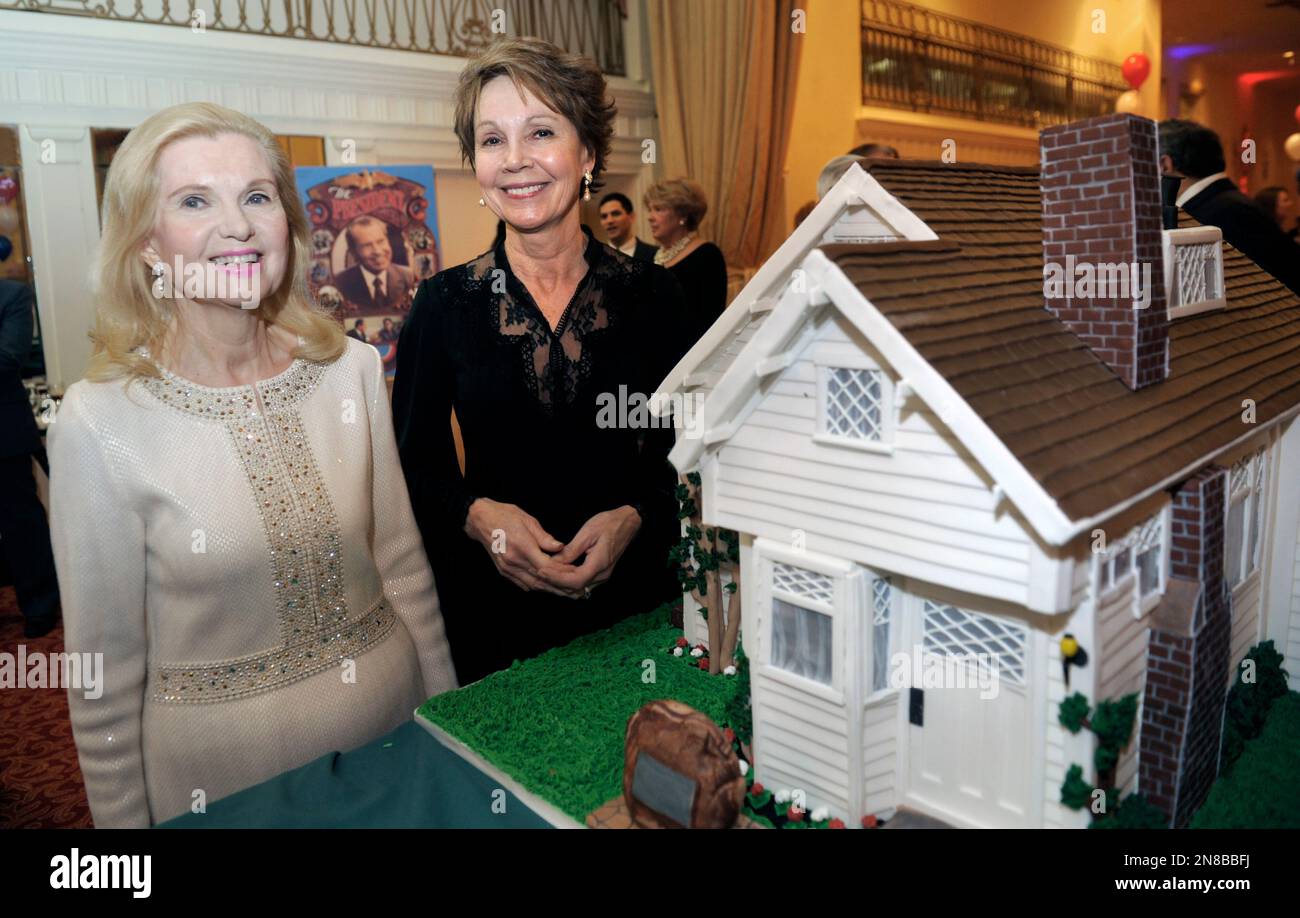Trisha Nixon Cox, left, and Julie Nixon Eisenhower pose with a cake designed like the birthplace of their father, President Richard Nixon, during the Richard Nixon Centennial Birthday Celebration in Washington, Wednesday, Jan. 9, 2013. The house, built by Nixon's father, Francis A. Nixon, from a home building kit. (AP Photo/Cliff Owen) Banque D'Images