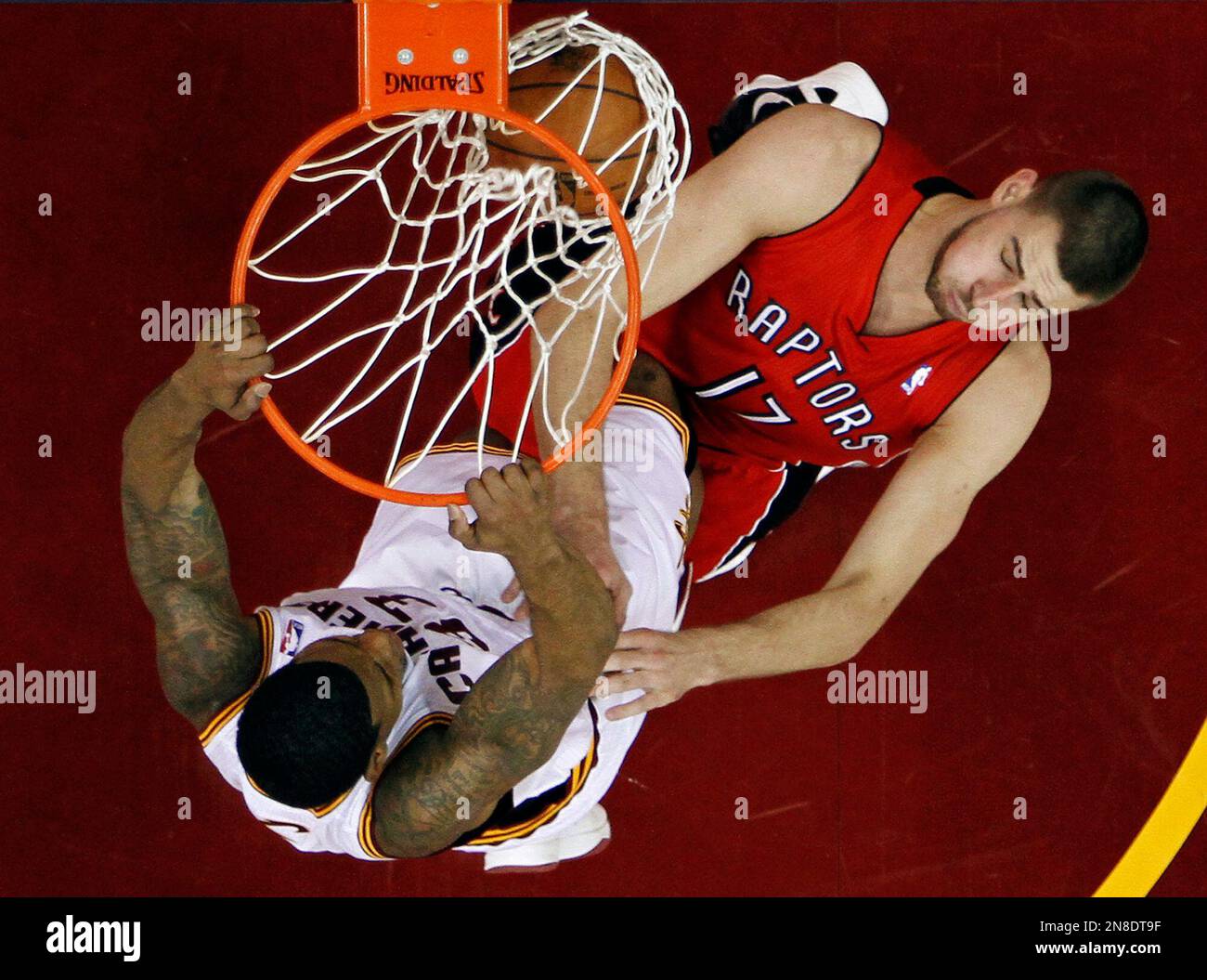 Cleveland Cavaliers' Alonzo Gee, left, dunks on Toronto Raptors' Jonas Valanciunas (17), of Lithuania, in the first half of an NBA basketball game, Tuesday, Dec. 18, 2012, in Cleveland. (AP Photo/Mark Duncan) Banque D'Images