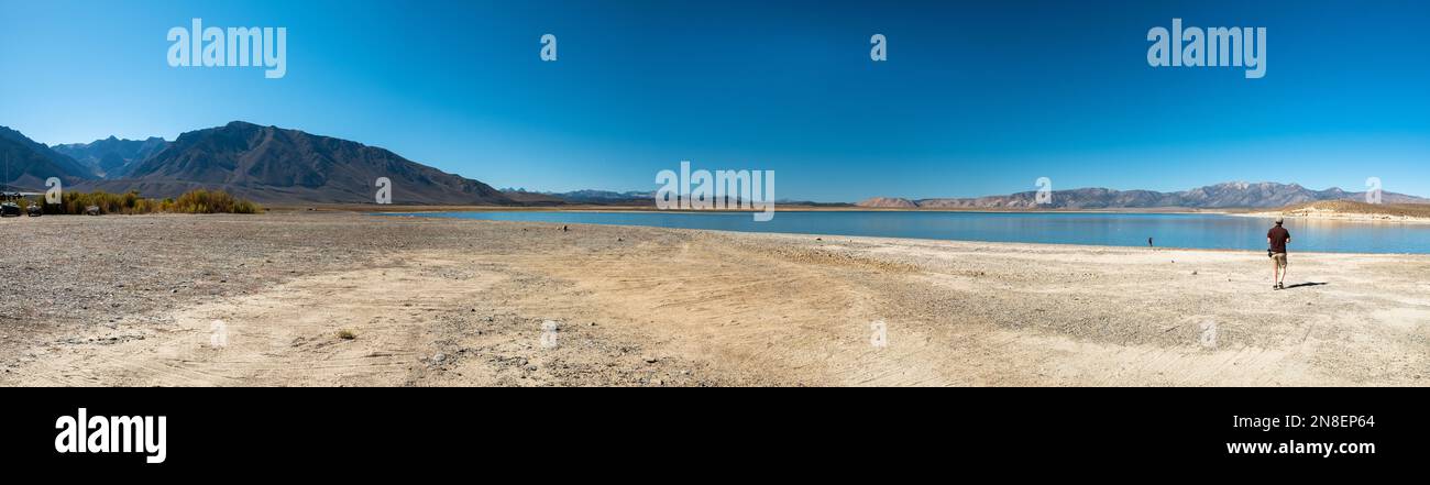 Vue panoramique sur le lac Crowley et les montagnes environnantes, pendant une journée ensoleillée. Une personne marche près du bord du lac. Banque D'Images