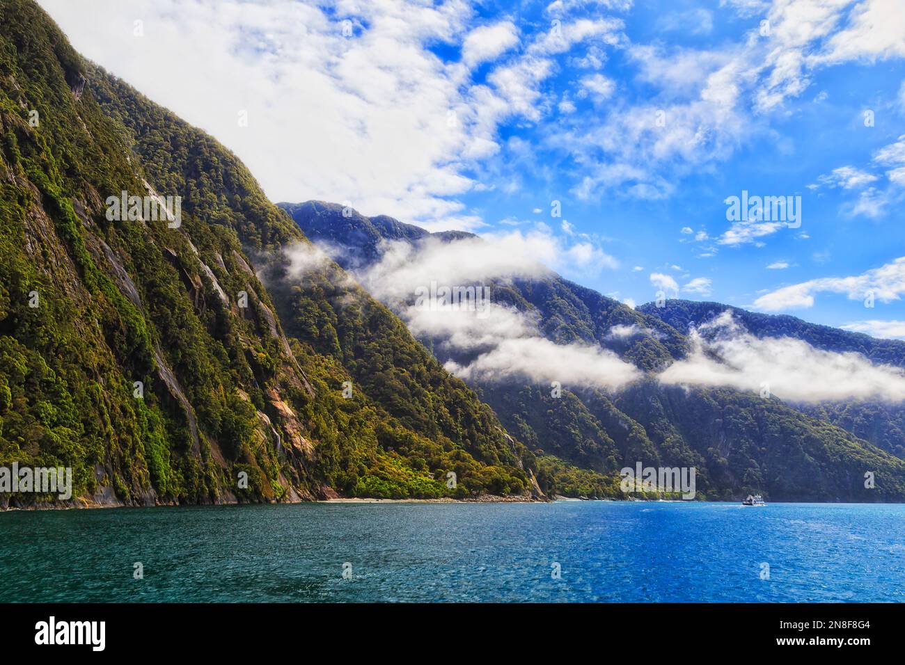 Le fjord de Milford Sound sur la côte pacifique de la Nouvelle-Zélande à partir d'une croisière en bateau sous un ciel bleu. Banque D'Images