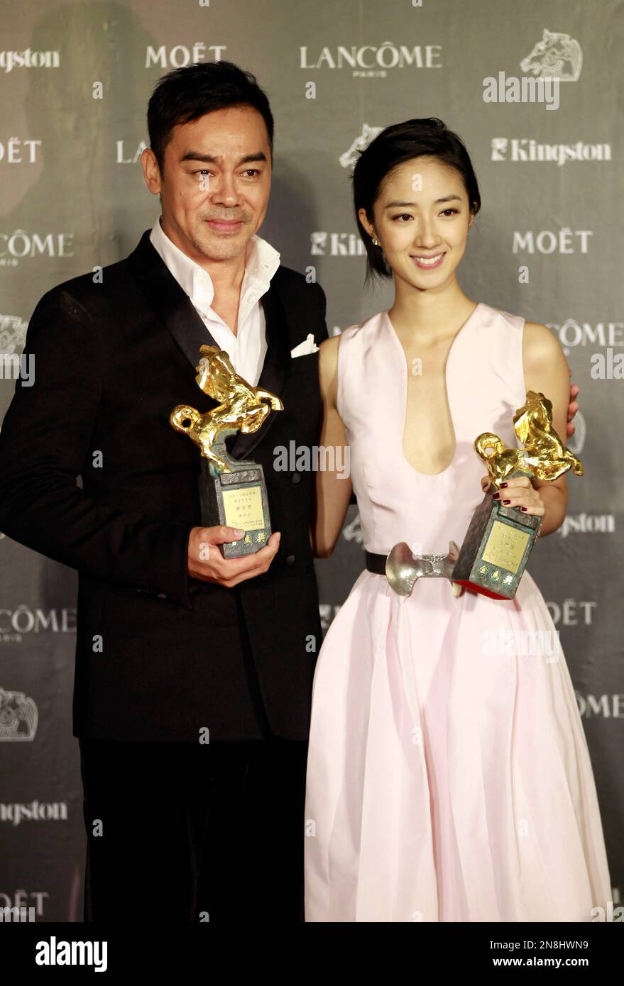 Taiwanese actress Gwei Lun-Mei and Hong Kong actor Lau ChingWan hold their awards for Best Actress and Best Actor for the film "GF * BF" and "Life Without Principle" at the 49th Golden Horse Awards at the Luodong Cultural Working House in Yilan County, Taiwan, Saturday, Nov. 24, 2012. The Golden Horse awards are the Chinese-language film industry's biggest annual events. (AP Photo/Wally Santana) Banque D'Images