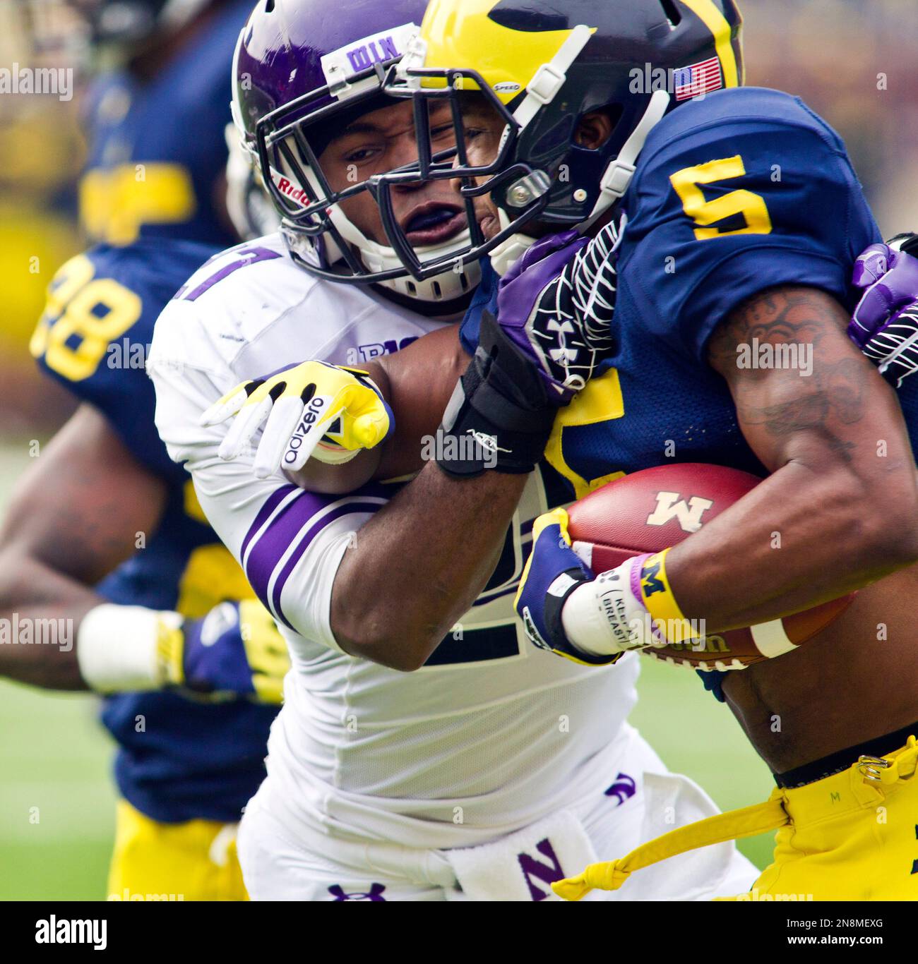 Northwestern safetey Jared Carpenter tries to stop Michigan running back Justice Hayes (5) in the first quarter of an NCAA college football game, Saturday, Nov. 10, 2012, in Ann Arbor, Mich. (AP Photo/Tony Ding) Banque D'Images