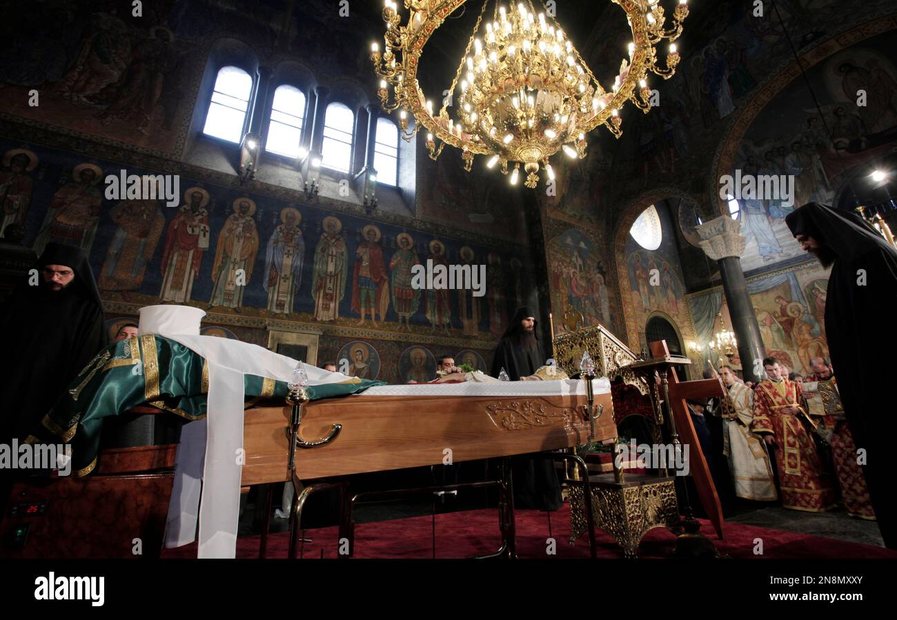 East Orthodox priests stand next to a coffin bearing the body of