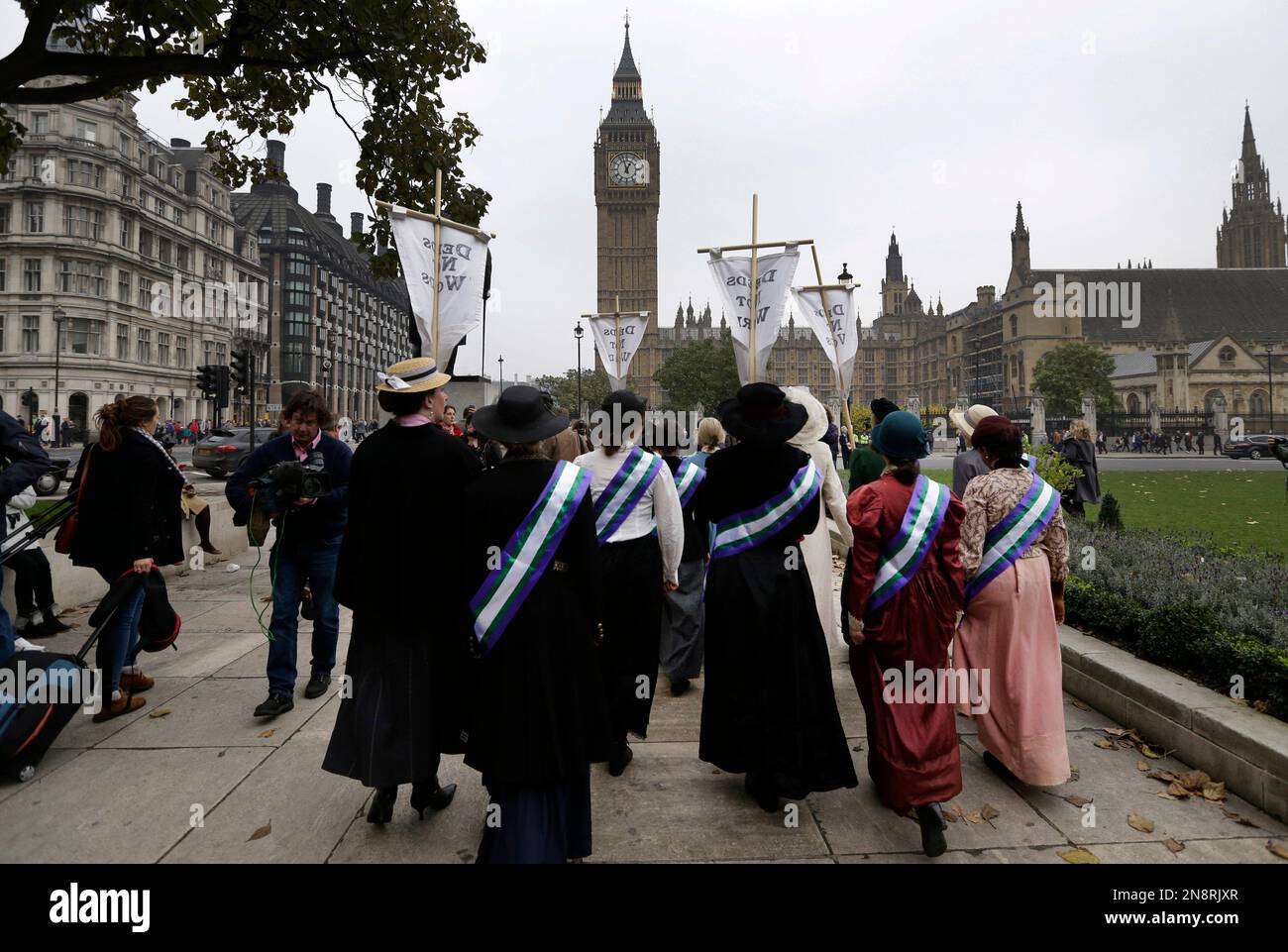 Women's rights activists from the UK Feminista organization, dressed as suffragettes, walk during a protest, across the Houses of Parliament in central London, Wednesday, Oct. 24, 2012. Suffragette leader Sylvia Pankhurst's granddaughter, Helen Pankhurst, led the protest over women's equality,106 years after her great grandmother, Emmeline, did the same. (AP Photo/Lefteris Pitarakis) Banque D'Images