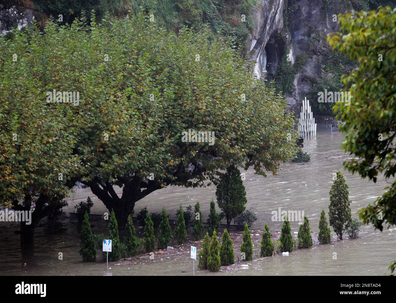A guardian of Lourdes sanctuary looks the Grotto of Lourdes flooded, in Lourdes, southwestern France, Saturday, Oct. 20, 2012. French rescue services and police are evacuating hundreds of pilgrims from hotels threatened by floodwaters from a rain-swollen river in the Roman Catholic shrine town of Lourdes. (AP Photo/Bob Edme) Banque D'Images