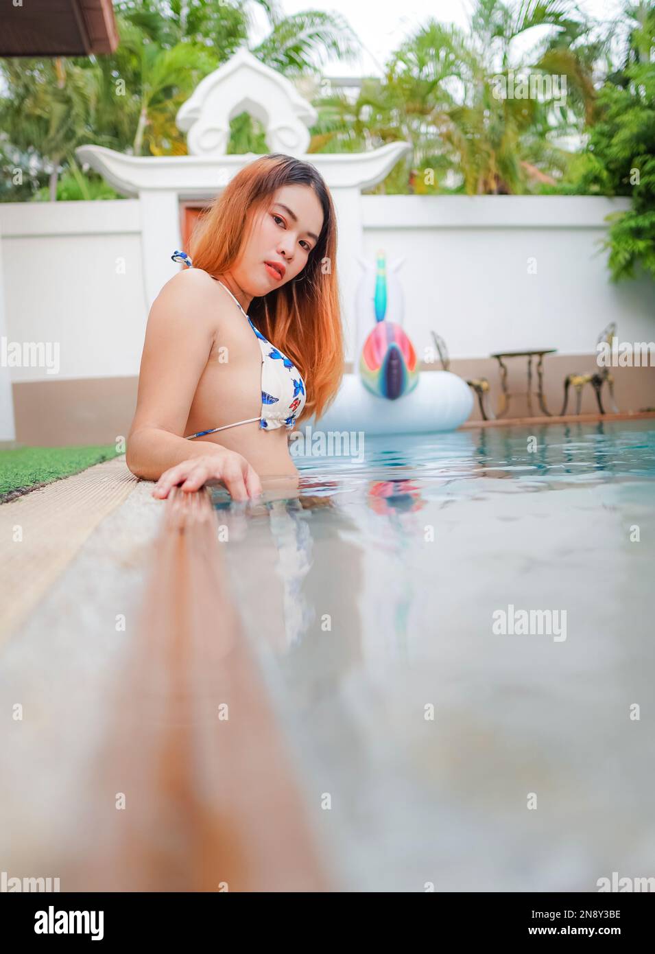 Asiatique jeune femme sexy portant un bikini blanc jouant dans la piscine à Pool Villa Banque D'Images