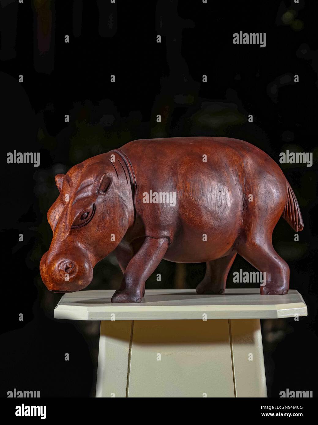 Jouet de rhinocéros en bois brun qui peut être utilisé à des fins décoratives, sur une table blanche avec fond noir. IL Banque D'Images