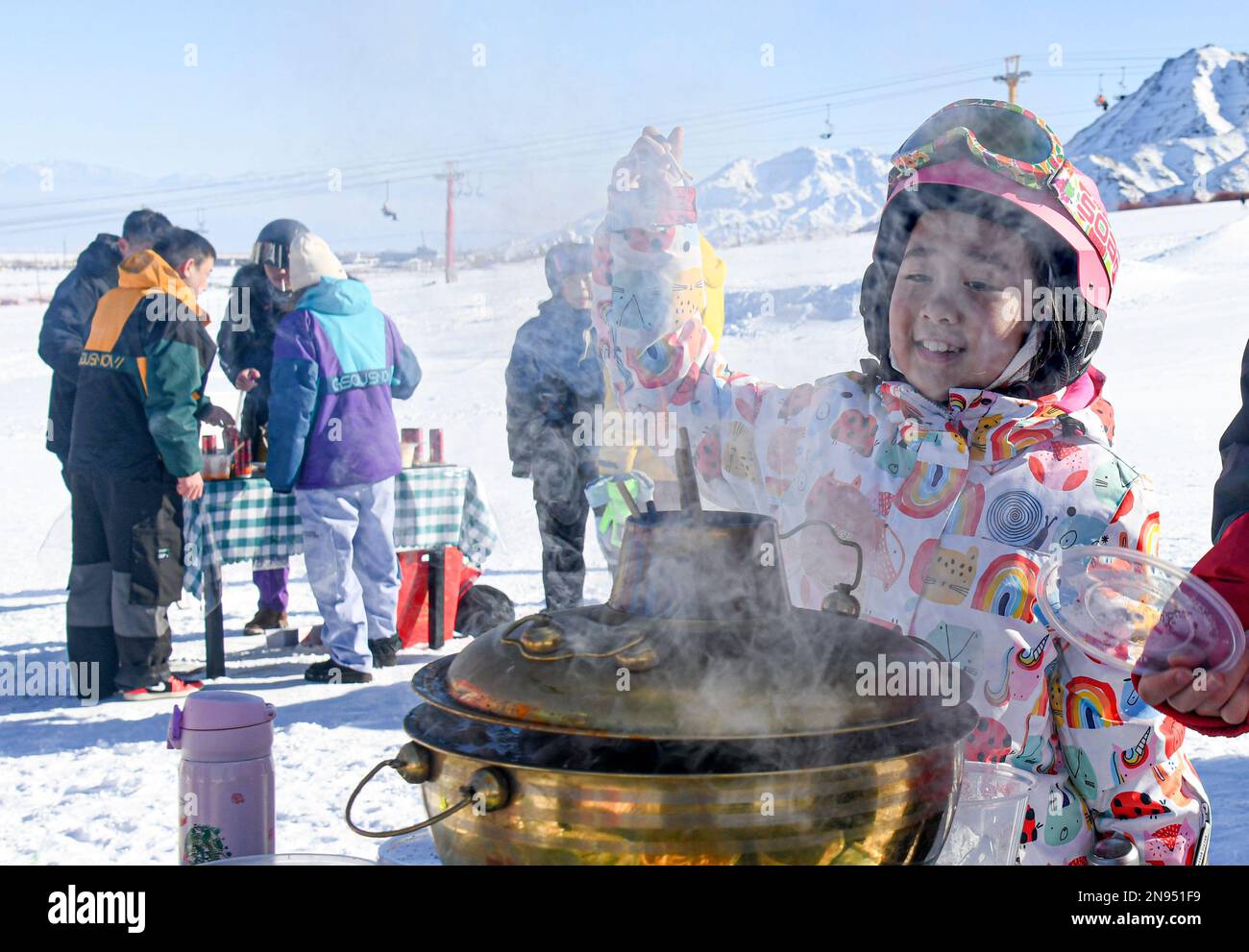 (230212) -- URUMQI, le 12 février 2023 (Xinhua) -- Une fille attend pour déguster un plat chaud dans une station de ski dans le comté d'Urumqi, dans la région autonome de Xinjiang Uygur, dans le nord-ouest de la Chine, le 13 janvier 2023. Xinjiang, qui bénéficie de conditions naturelles favorables et de nombreuses stations de ski de haut niveau, a joué un rôle de premier plan dans l'industrie en plein essor pour devenir l'une des destinations touristiques d'hiver les plus populaires du pays. (Xinhua/Wang FEI) Banque D'Images