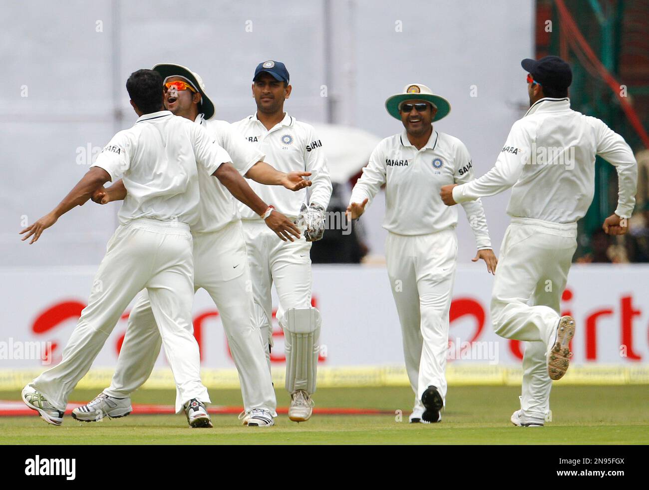 India's bowler Umesh Yadav, left back to camera, celebrates with teammates after taking the wicket of New Zealand batsman Brendon McCullum, not seen, during the third day of their second cricket test match in Bangalore, India, Sunday, Sept. 2, 2012. India leads the series 1-0. (AP Photo/Aijaz Rahi) Banque D'Images