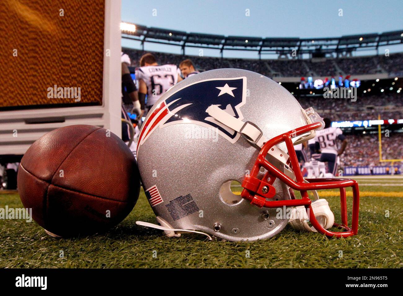 A New England Patriots helmet sits on the sideline next to a football during the first half of a preseason NFL football game between the New York Giants and the New England Patriots Wednesday, Aug. 29, 2012, in East Rutherford, N.J. (AP Photo/Julio Cortez) Banque D'Images