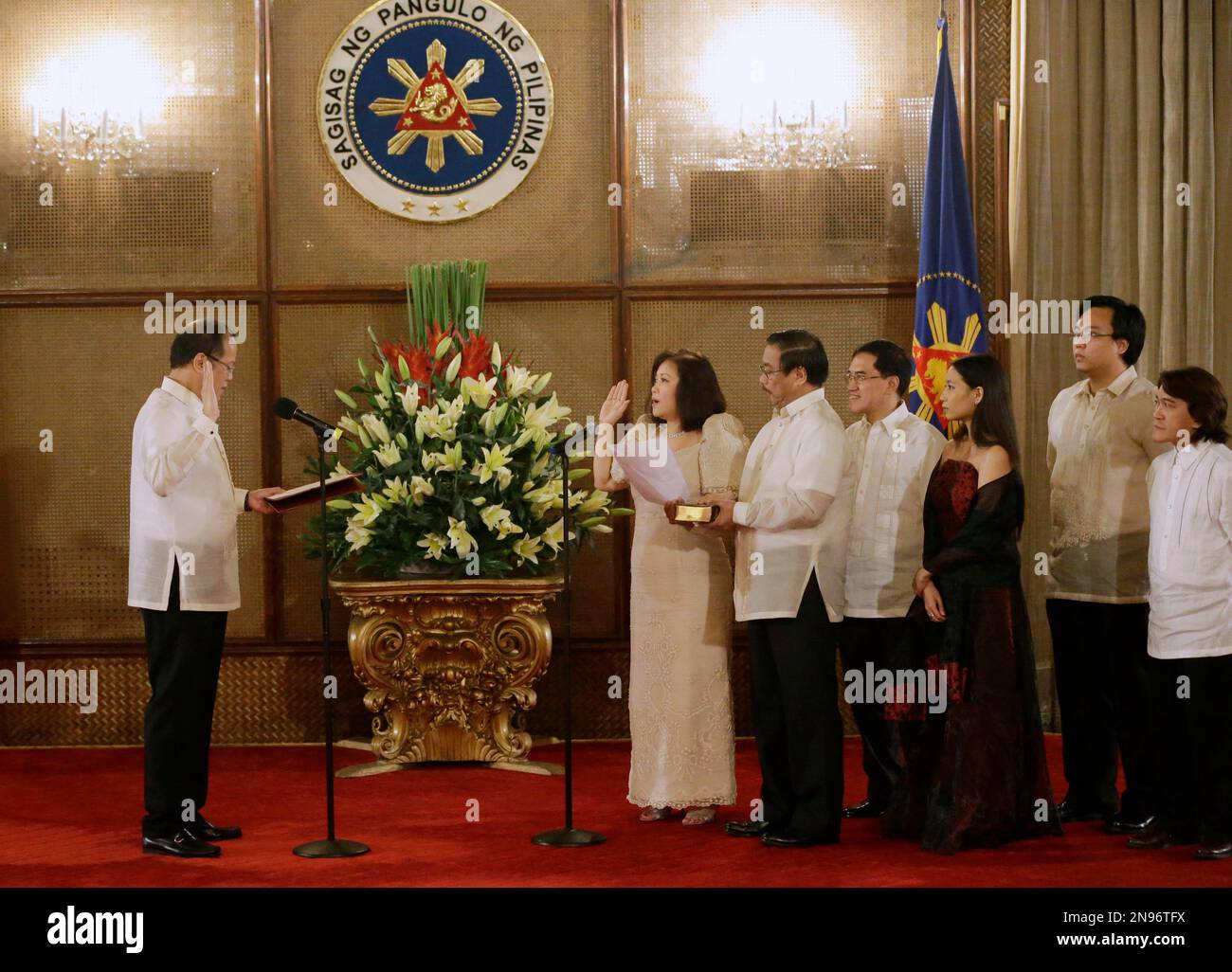 Philippine President Benigno Aquino III, left, administers the oath to his newly appointed Philippine Supreme Court Chief Justice Maria Lourdes Sereno, sixth from right, during her oath-taking ceremony Saturday, Aug. 25, 2012 at Malacanang Palace in Manila, Philippines. Sereno, who replaced impeached chief justice Renato Corona, becomes the country's first female chief justice of the highest court. Fifth from right is Sereno's husband Mario Jose Sereno. (AP Photo/Bullit Marquez) Banque D'Images
