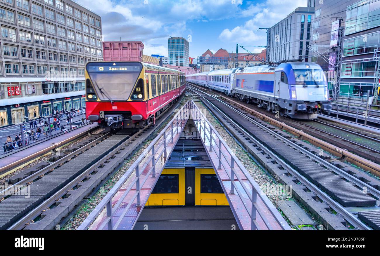 Trains à l'approche de la gare Alexanderplatz dans le centre de Berlin, en Allemagne. Vous trouverez ci-dessous un tramway BVG jaune. Banque D'Images