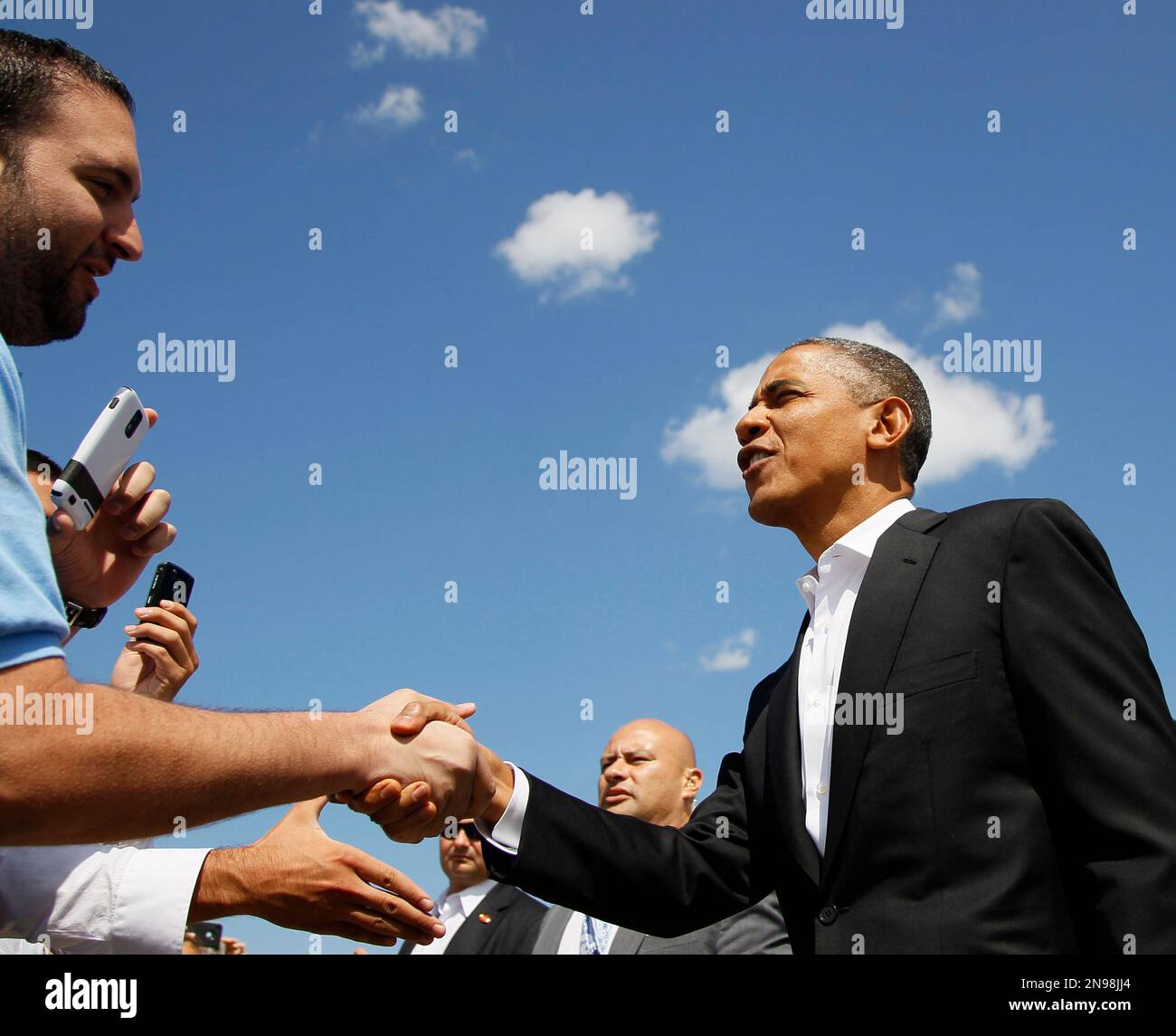 President Barack Obama greets people waiting for him on the tarmac as he arrives at O'Hare International Airport on Air Force One, Saturday, Aug. 11, 2012, in Chicago. (AP Photo/Carolyn Kaster) Banque D'Images