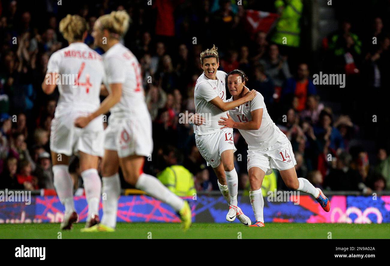 Canada's Christine Sinclair, centre, celebrates with teammates including Melissa Tancredi, right, after scoring her second goal against the United States during their semifinal women's soccer match at the 2012 London Summer Olympics, Monday, Aug. 6, 2012 at Old Trafford Stadium in Manchester, England. (AP Photo/Jon Super) Banque D'Images