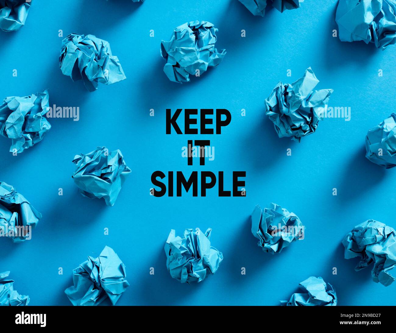 Gardez un message simple avec des boules de papier bleu froissés sur fond bleu. Principe de simplicité pour l'efficacité et l'efficience dans les affaires ou l'éducation Banque D'Images