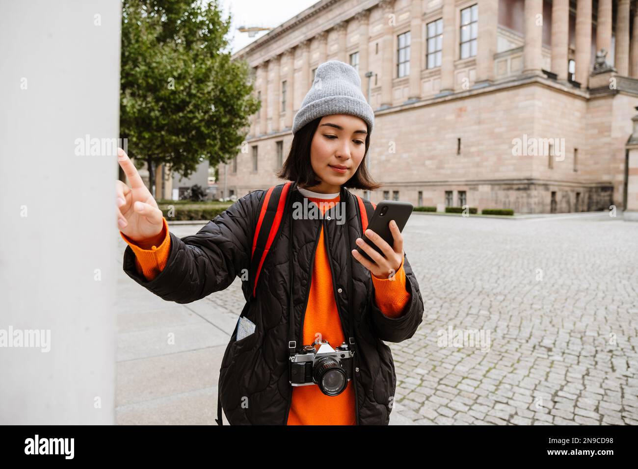 Belle femme asiatique touriste avec sac à dos et appareil photo utilisant un smartphone pendant la marche dans la vieille ville rue Banque D'Images