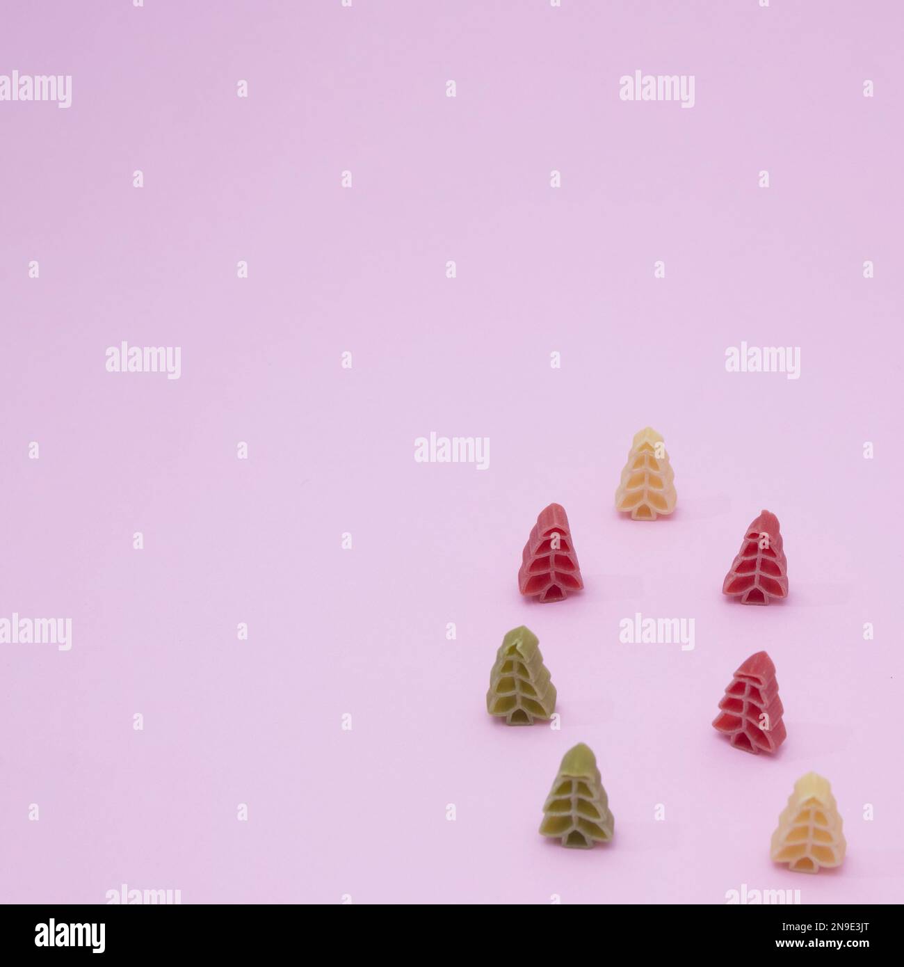 Vue panoramique sur les pâtes colorées en forme d'arbres de Noël sur fond rose Banque D'Images