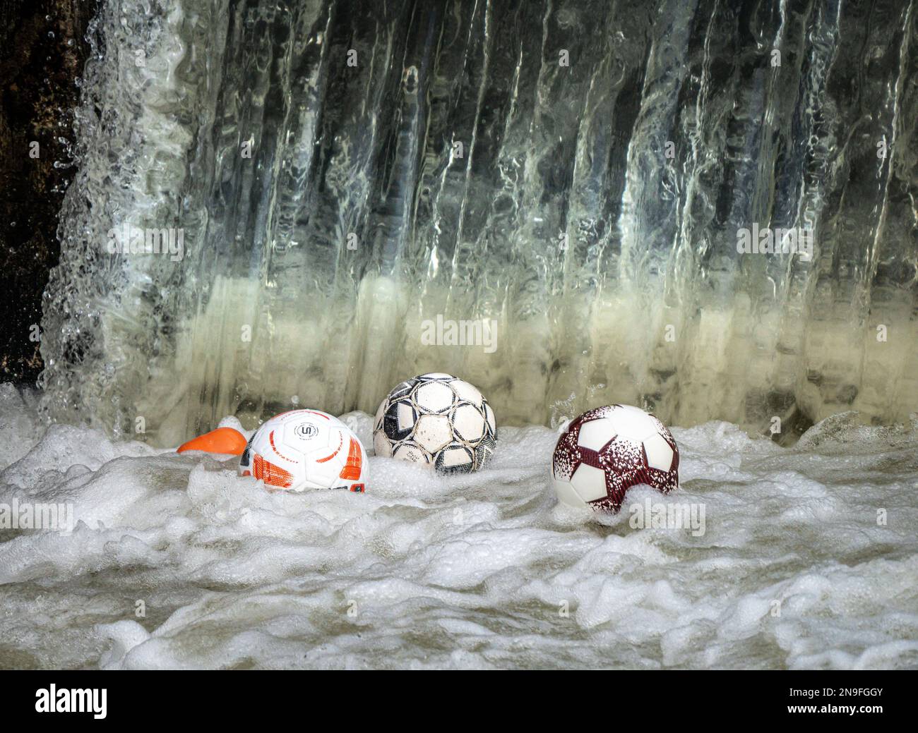 12 février 2023, Hesse, Francfort-sur-le-main: Des ballons de football dansent sur l'eau à un déversoir sur le fleuve Nidda, où ils sont pris dans le sous-sol de l'eau. La petite rivière passe devant de nombreux terrains de sport et installations de loisirs dans le nord de Francfort et les villes voisines, d'où les balles continuent de tomber dans l'eau. Photo: Frank Rumpenhorst/dpa/Frank Rumpenhorst/dpa Banque D'Images