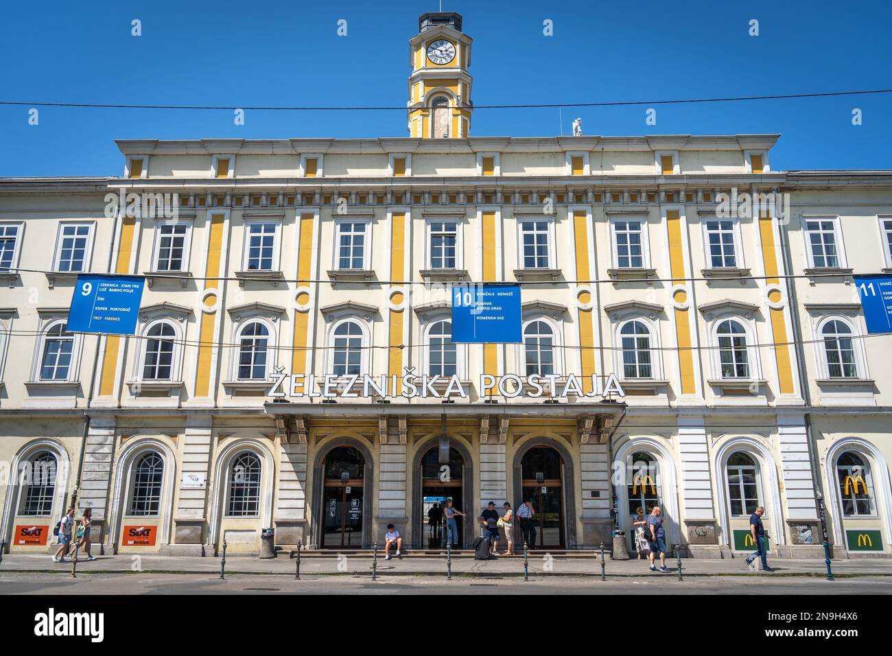 Façade du bâtiment de la gare de Ljubljana avec les gens près de l'entrée à l'heure de la journée en été Banque D'Images