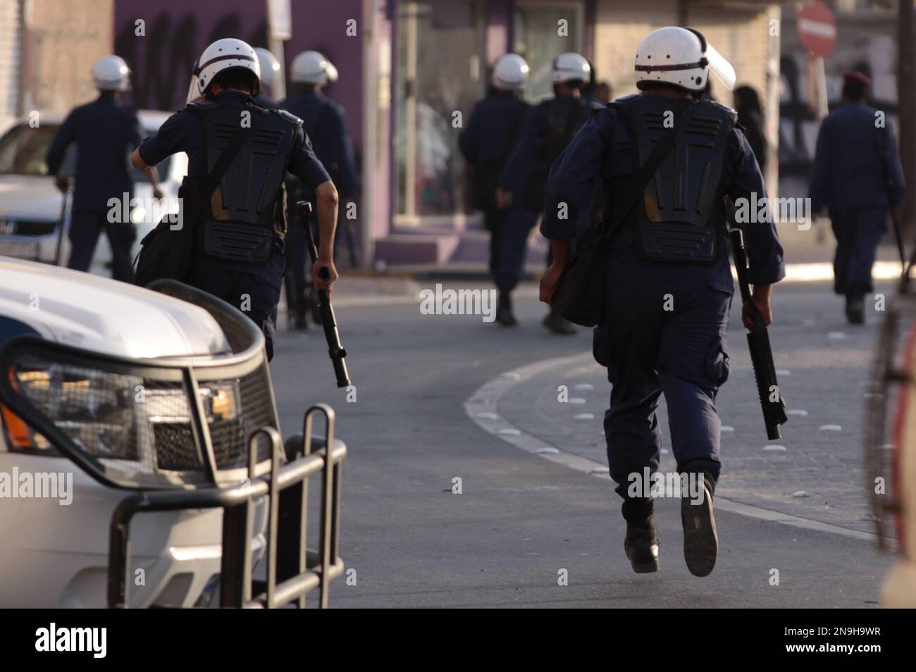 Riot police chase Bahraini anti-government protesters in Buri, Bahrain, southwest of the capital of Manama, on Wednesday, June 27, 2012. Prominent Bahraini human rights activist Zainab al-Khawaja was shot in the leg with a tear gas canister and taken to a hospital by another activist. (AP Photo/Hasan Jamali) Banque D'Images