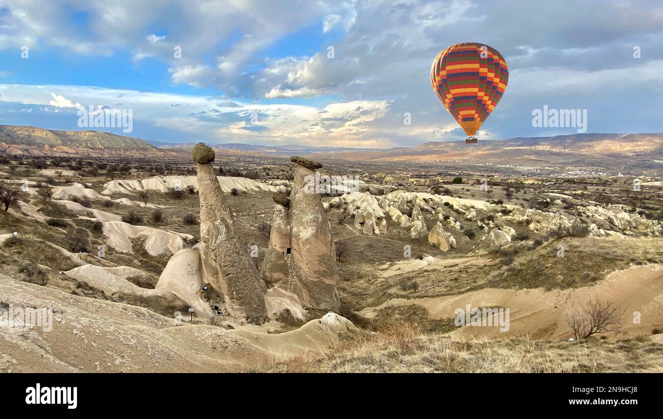 Montgolfière touristique sur trois Grâces, trois collines rocheuses Beautifuls (uc guzeller) dans la vallée du Devrent, Cappadoce, Nevsehir, Turquie Banque D'Images
