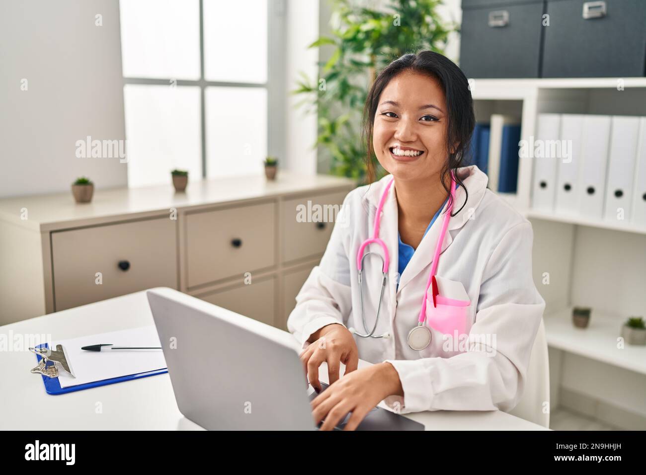 Jeune femme chinoise portant un uniforme de médecin utilisant un ordinateur  portable à la clinique Photo Stock - Alamy