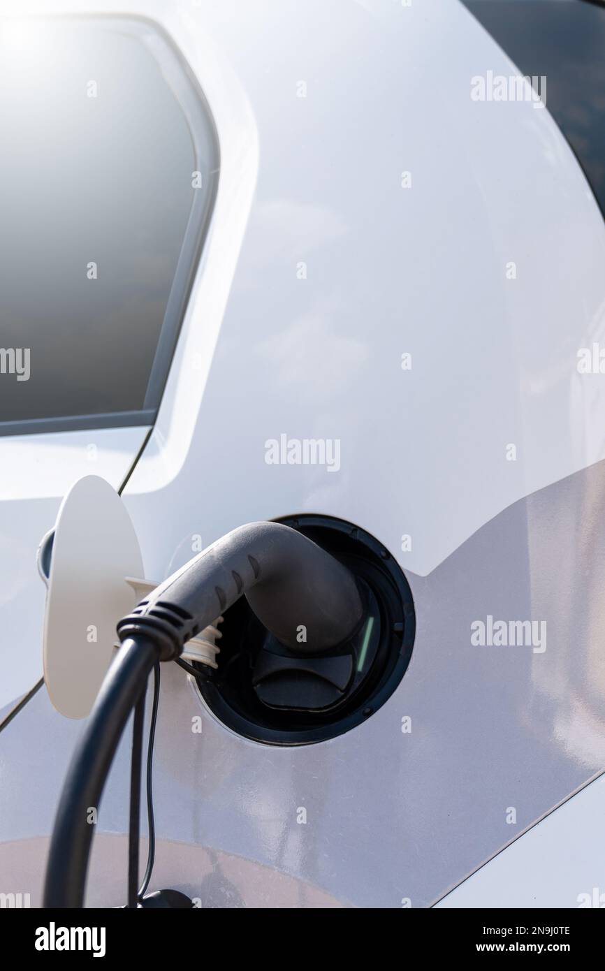 Gros plan de l'entrée électrique de la voiture avec un câble de charge connecté Banque D'Images