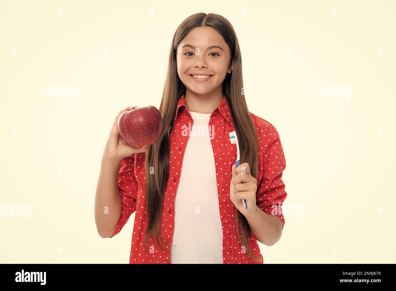 La brosse à dents de maintien de fille d'adolescence, le bonheur d'enfance, la routine du matin. Brosser les dents, soins dentaires et soins buccaux. Enfant brosse ses dents. Vitamines de pomme pour h Banque D'Images