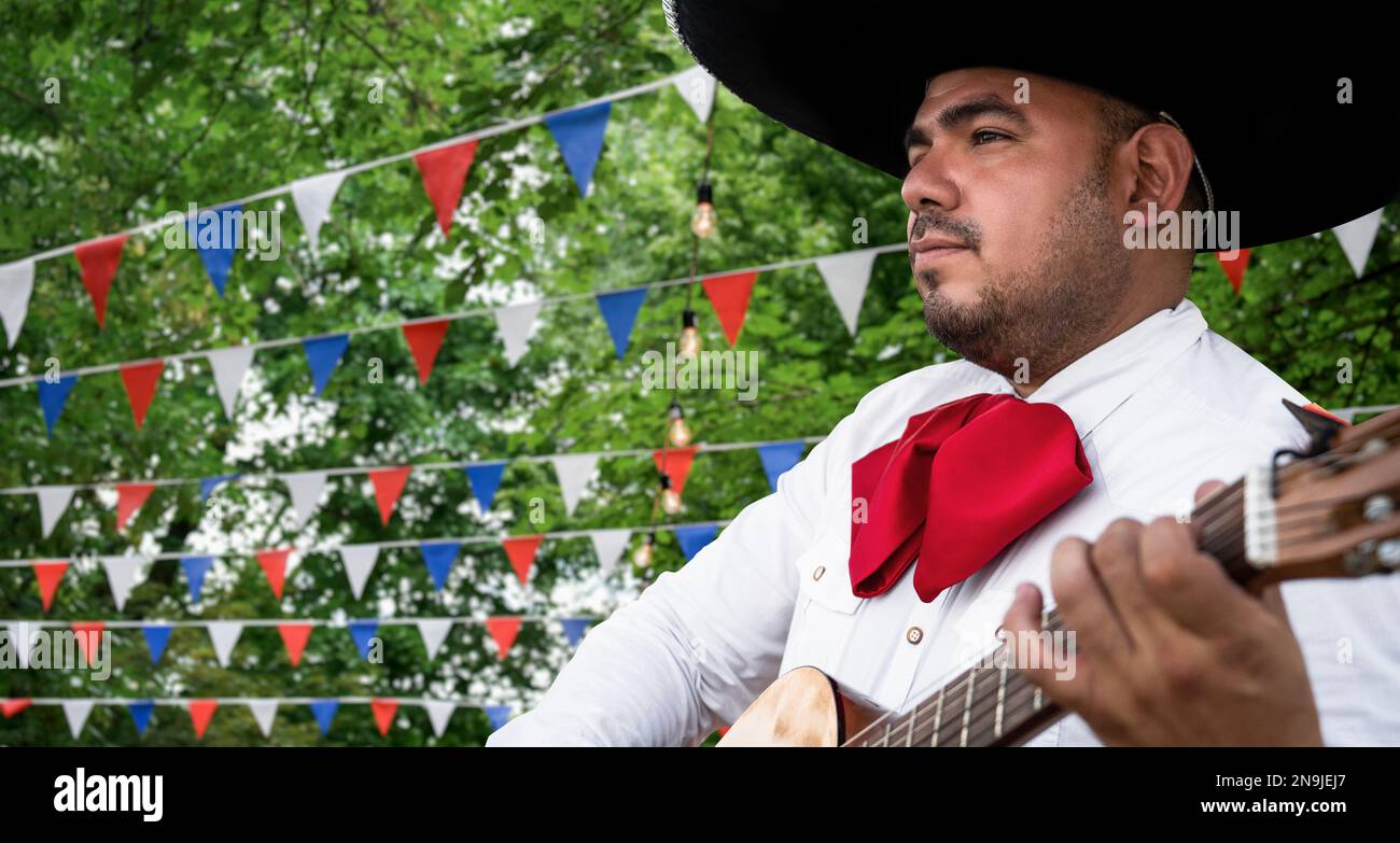 Musicien mexicain mariachi avec guitare sur fond flou de fête Banque D'Images