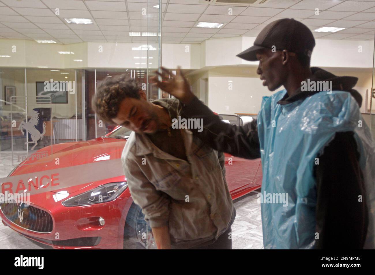 A homeless man, right, who did not want to be identified, slaps a fellow homeless man during dispute about some food as they shelter in front of a motor dealer selling luxury cars in the city of Cape Town, South Africa, Friday, June 8, 2012. A group of five homeless people have been sleeping in front of the dealership for past weeks since extreme winter weather descended on the Western Province. (AP Photo/Schalk van Zuydam) Banque D'Images