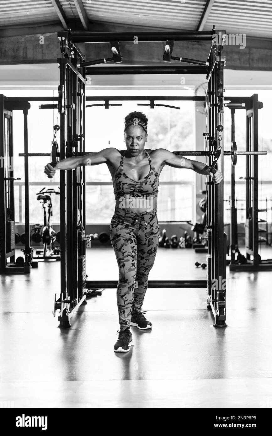 Femme musclée faisant des exercices de bras sur une machine à la salle de  gym. Détermination et concentration Photo Stock - Alamy