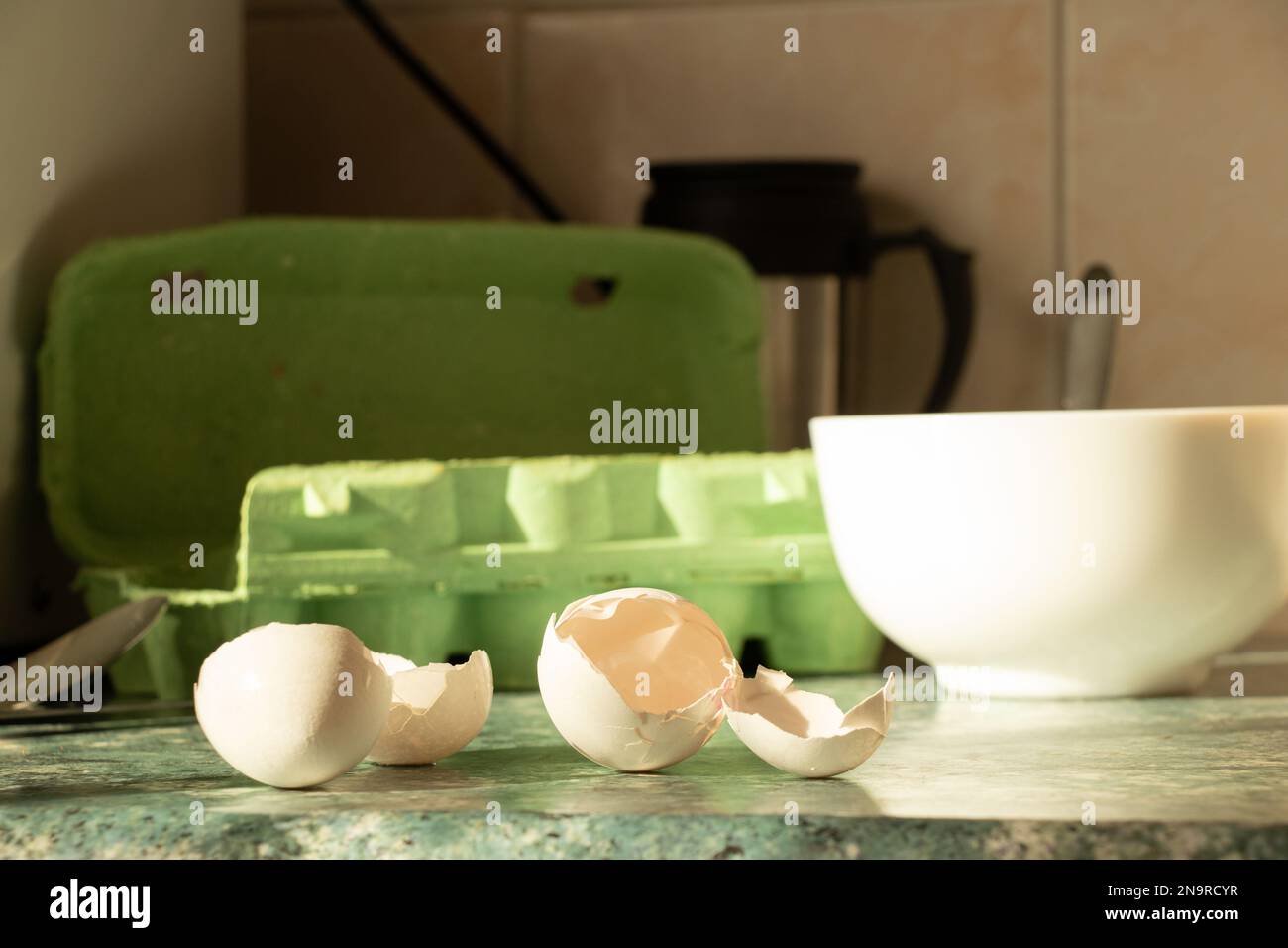 Une coquille d'œuf cassée se trouve sur la table de cuisine près de l'assiette, faire cuire une omelette, dîner Banque D'Images