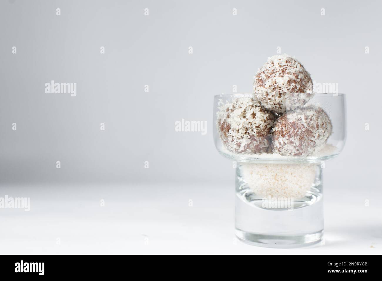 Truffes au chocolat et à la noix de coco, bonbons au chocolat faits maison sur fond blanc, truffes séchées enrobées de noix de coco Banque D'Images
