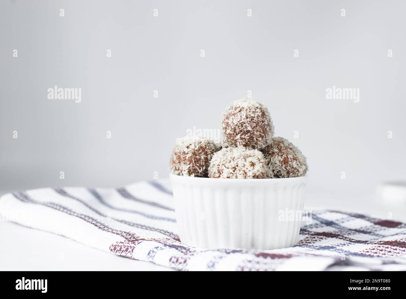 Truffes au chocolat et à la noix de coco, bonbons au chocolat faits maison sur fond blanc, truffes séchées enrobées de noix de coco Banque D'Images