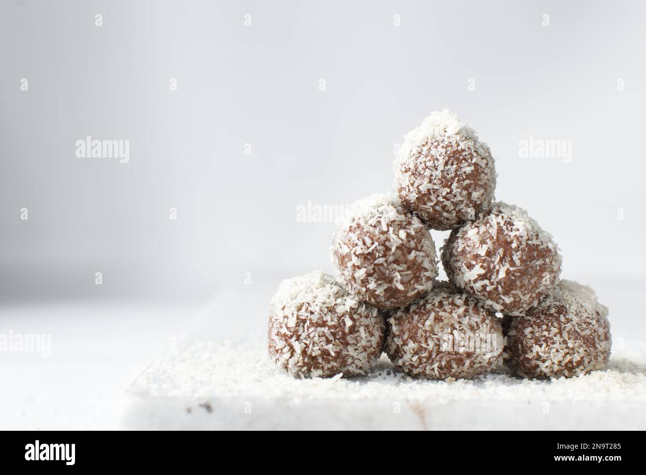 Truffes au chocolat et à la noix de coco, bonbons au chocolat faits maison sur fond blanc, truffes séchées enrobées de noix de coco Banque D'Images