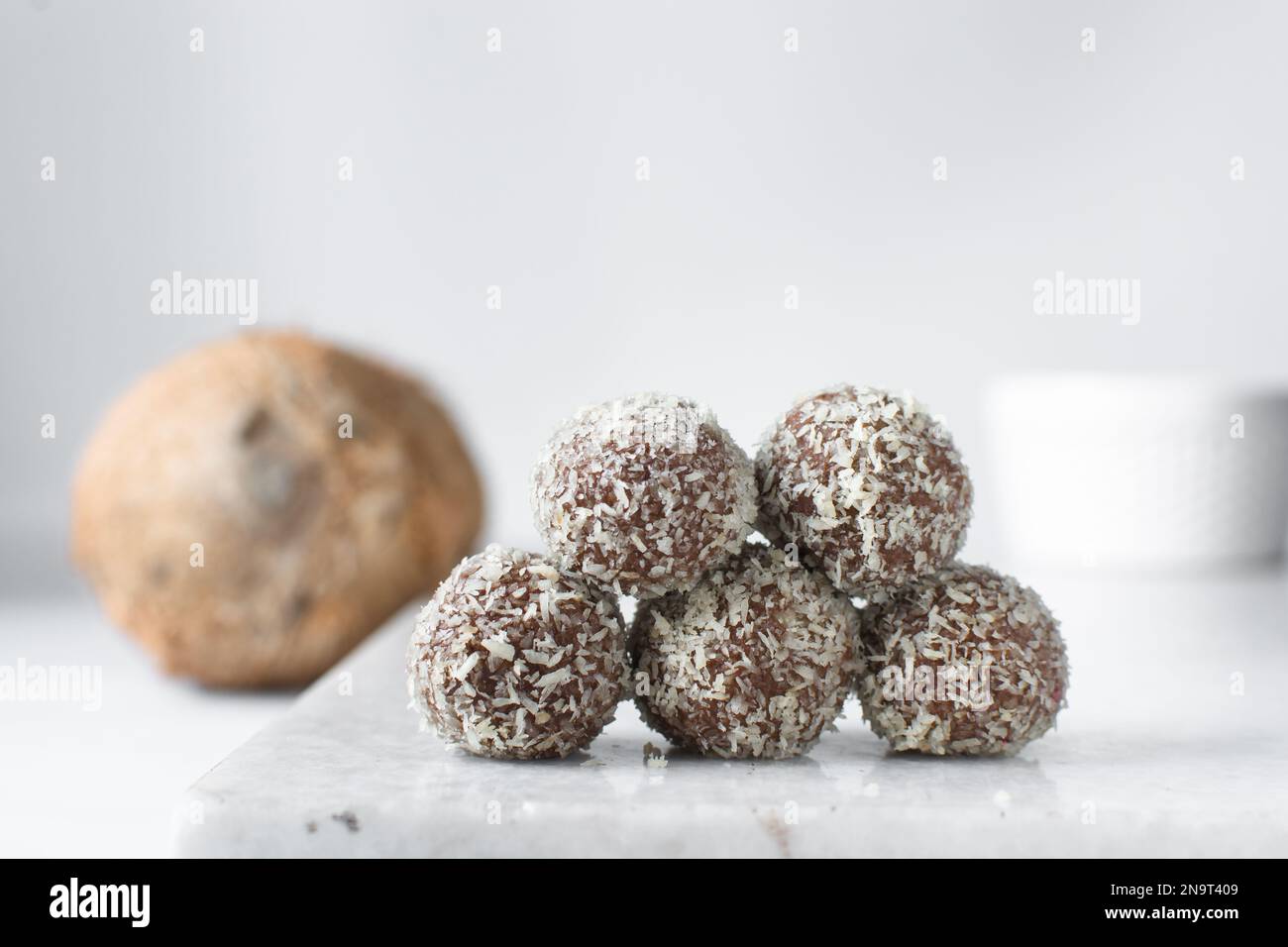 Truffes au chocolat et à la noix de coco, bonbons au chocolat faits maison sur fond blanc, truffes séchées enrobées de noix de coco Banque D'Images