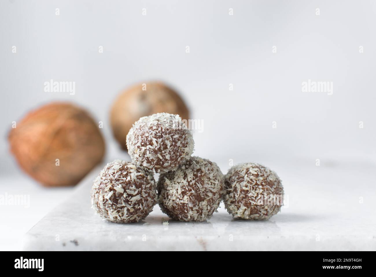 Truffes au chocolat et à la noix de coco, bonbons au chocolat faits maison sur fond blanc, truffes séchées enrobées de noix de coco Banque D'Images