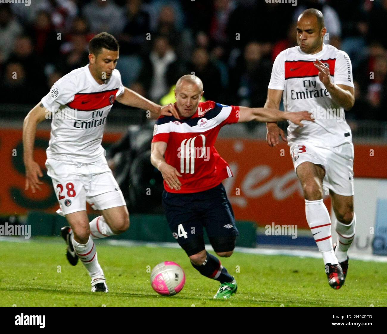 PSG's midfilelder Motta Thiago, left, Lille's midfielder Florent Balmont, center, an PSG's defender Alex challenge the ball during their French League one soccer match, in Villeneuve d'Ascq, northern France, Sunday, April 29, 2012. (AP Photo/Michel Spingler) Banque D'Images