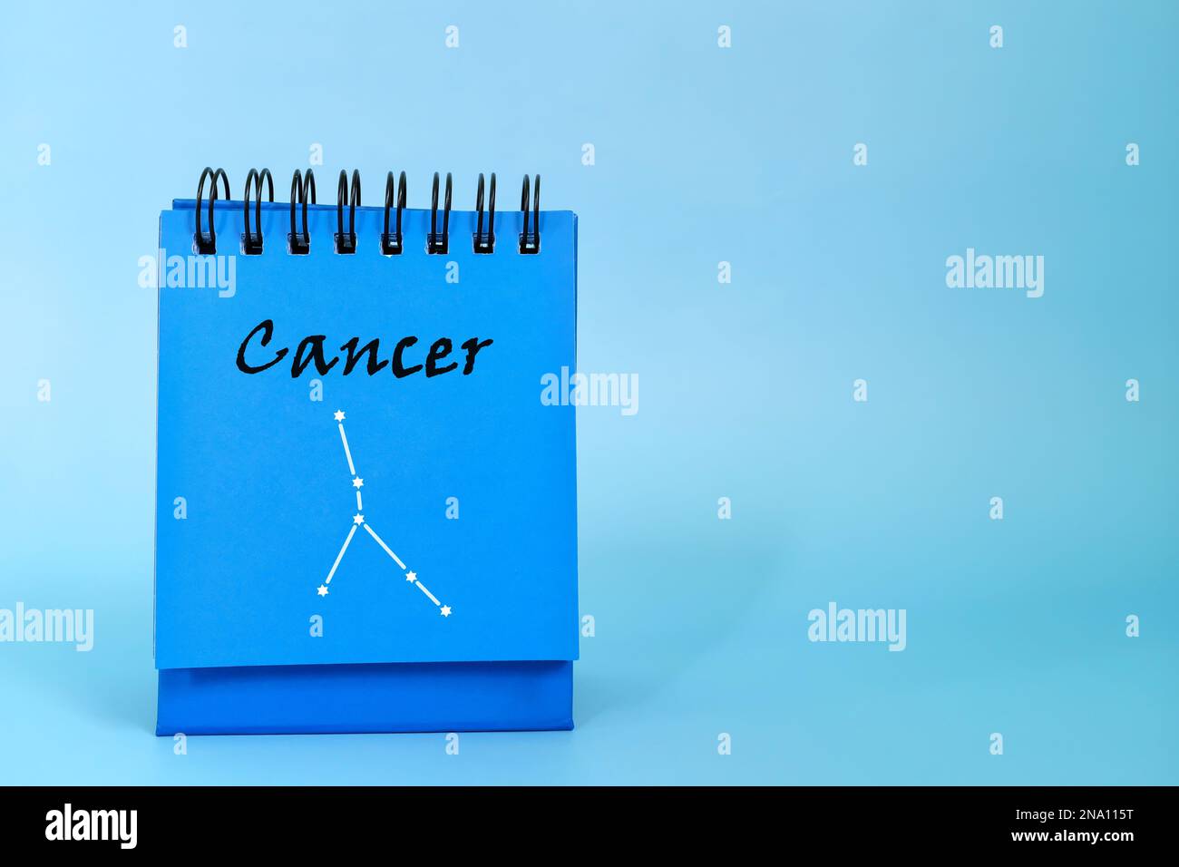 Signe de zodiaque de cancer sur le bloc-notes bleu de calendrier de bureau. Horoscope et astrologie. Banque D'Images