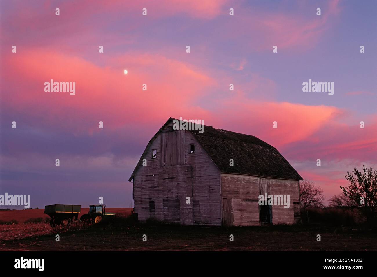 Tracteur et une grange rustique sous un ciel de prairie ; Dunbar, Nebraska, États-Unis d'Amérique Banque D'Images