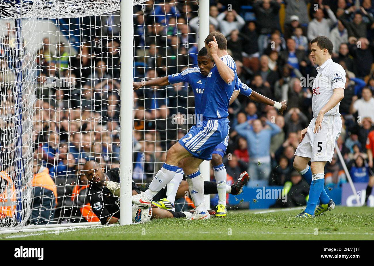 Chelsea's Branislav Ivanovic, center ensures the ball crosses the line after Juan Mata, unseen, scores the winning goal past Wigan Athletic's goalkeeper Ali Al Habsi during their English Premier League soccer match at Chelsea's Stamford Bridge stadium in London, Saturday, April 7, 2012. (AP Photo/Alastair Grant) Banque D'Images