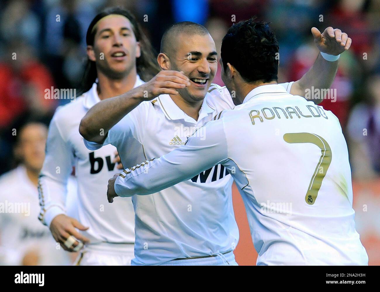Real Madrid's Karim Benzema from France, center, is congratulated by his fellow teammate Cristiano Ronaldo from Portugal , right, after he scored against Osasuna, during their Spanish La Liga soccer match, at Reyno de Navarra stadium in Pamplona, northern Spain, Saturday March 31, 2012. (AP Photo/Alvaro Barrientos) Banque D'Images