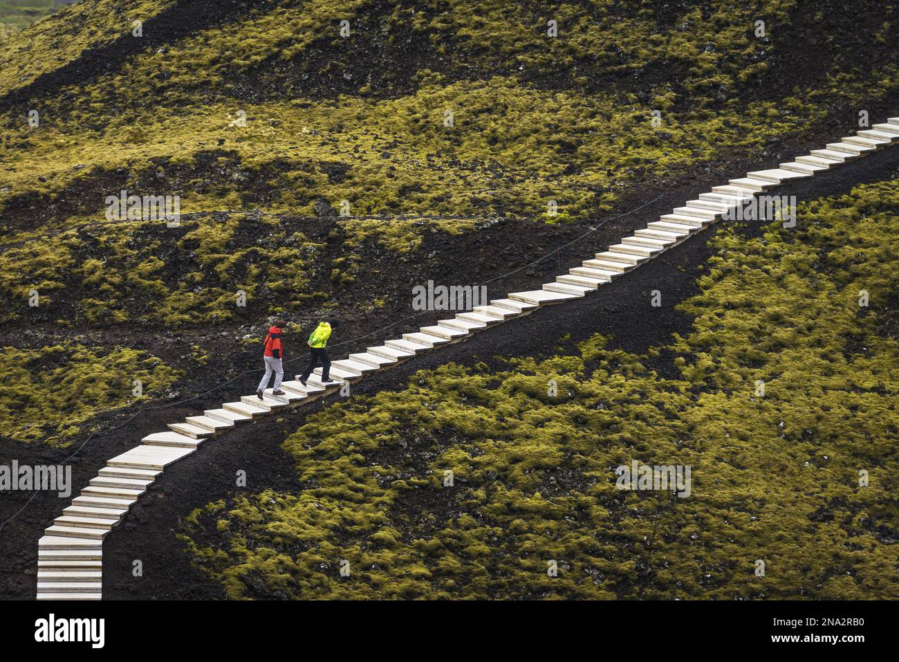 Couple montant des marches autour du cratère Grabrok ; Islande Banque D'Images