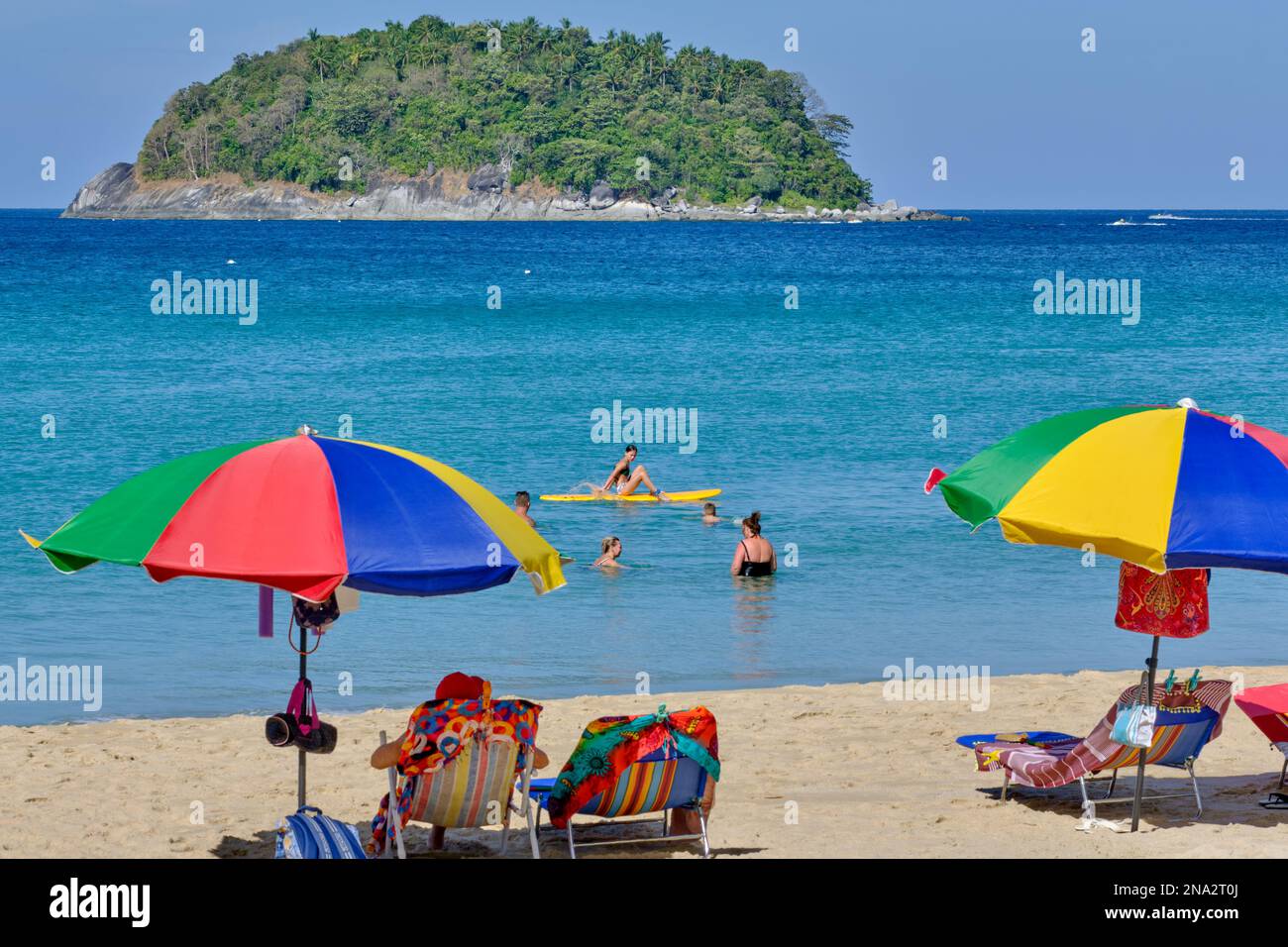 Touristes nageant dans la mer ou allongé sous des parasols à Kata Yai Beach à Phuket, Thaïlande Banque D'Images
