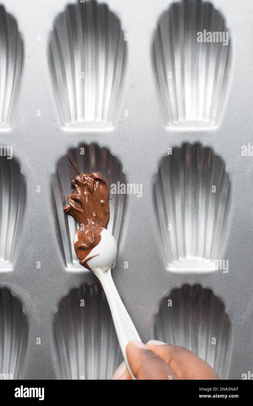 Chocolat fondu dans une casserole de madeleine, processus de fabrication de madeleines enrobées de chocolat Banque D'Images