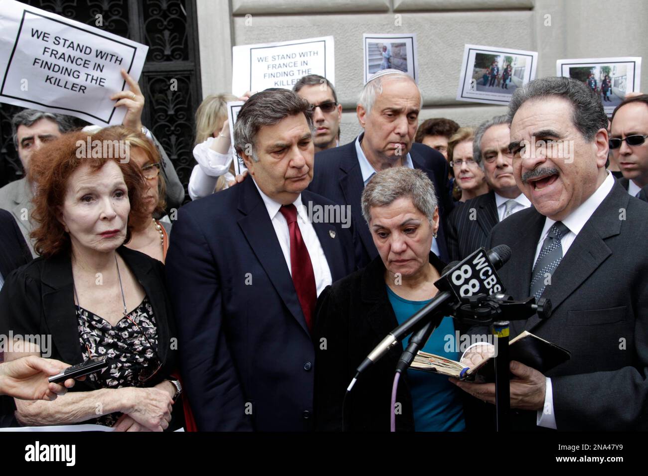About two dozen people gather to memorialize the victims of the recent shootings in France in front of the French Consulate in New York, Tuesday, March 20, 2012. The group gathered to express their support for efforts to find the killer and offer prayers for the victims. (AP Photo/Seth Wenig) Banque D'Images