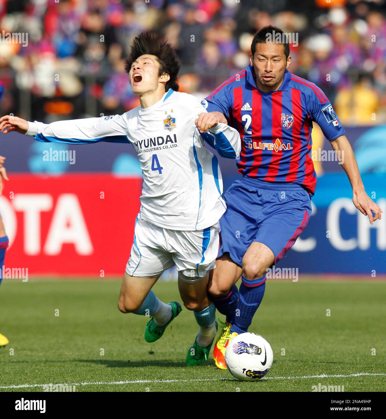 Yuhei Tokunaga of FC Tokyo, right, and Kang Min-soo of South Korea's Ulsan Hyundai battle for the ball during an AFC Champions League soccer group F match at the National Stadium in Tokyo,Tuesday, March 20, 2012. The match ended in 2-2 draw. (AP Photo/Koji Sasahara) Banque D'Images