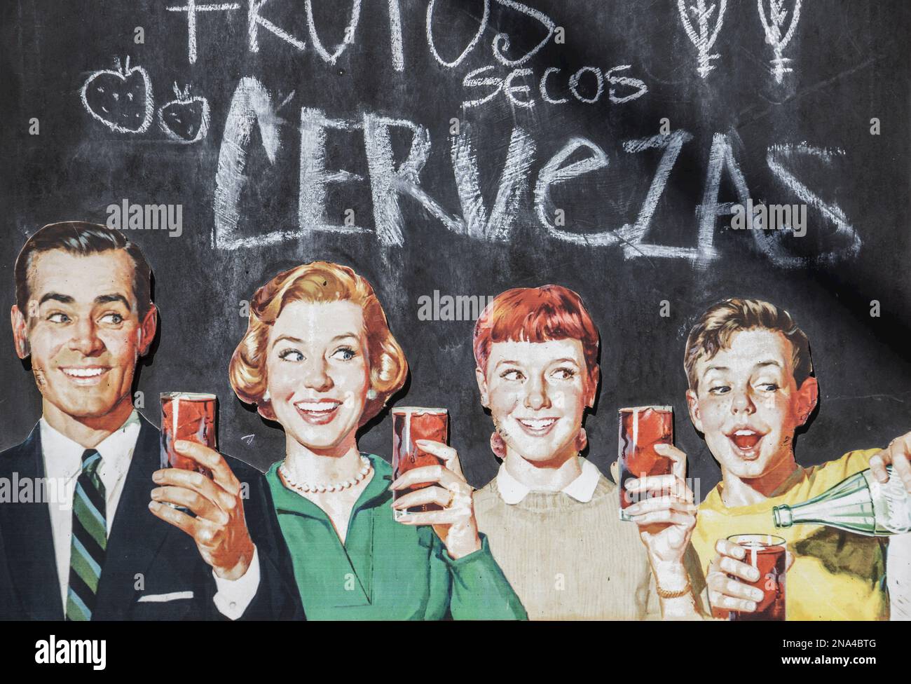 Publicité vintage pour une boisson au cola avec une famille debout et tenant des verres de la boisson, et un message sur la bière en espagnol sur la craie... Banque D'Images