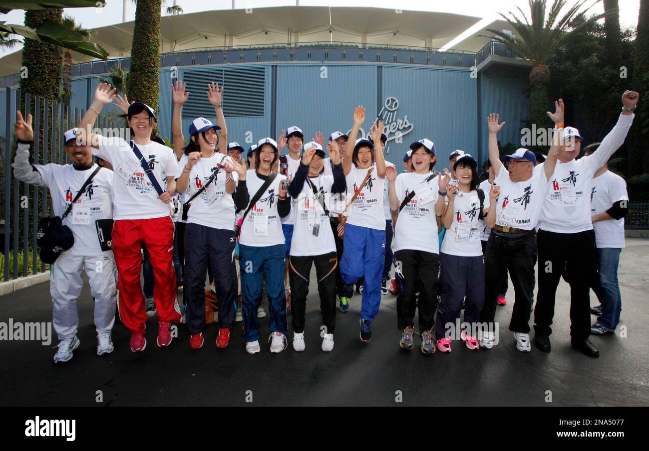 A group of 35 Japanese tsunami survivors cheer during a visit to Dodger Stadium Thursday March 15, 2012, in Los Angeles. The group, part of a charity event, includes two high school-aged orphans, six high school students and eight college students. The group was brought to the U.S. by the nonprofit charity group Ashinaga. A group of 15 will be running the L.A. Marathon on Sunday.(AP Photo/Nick Ut) Banque D'Images
